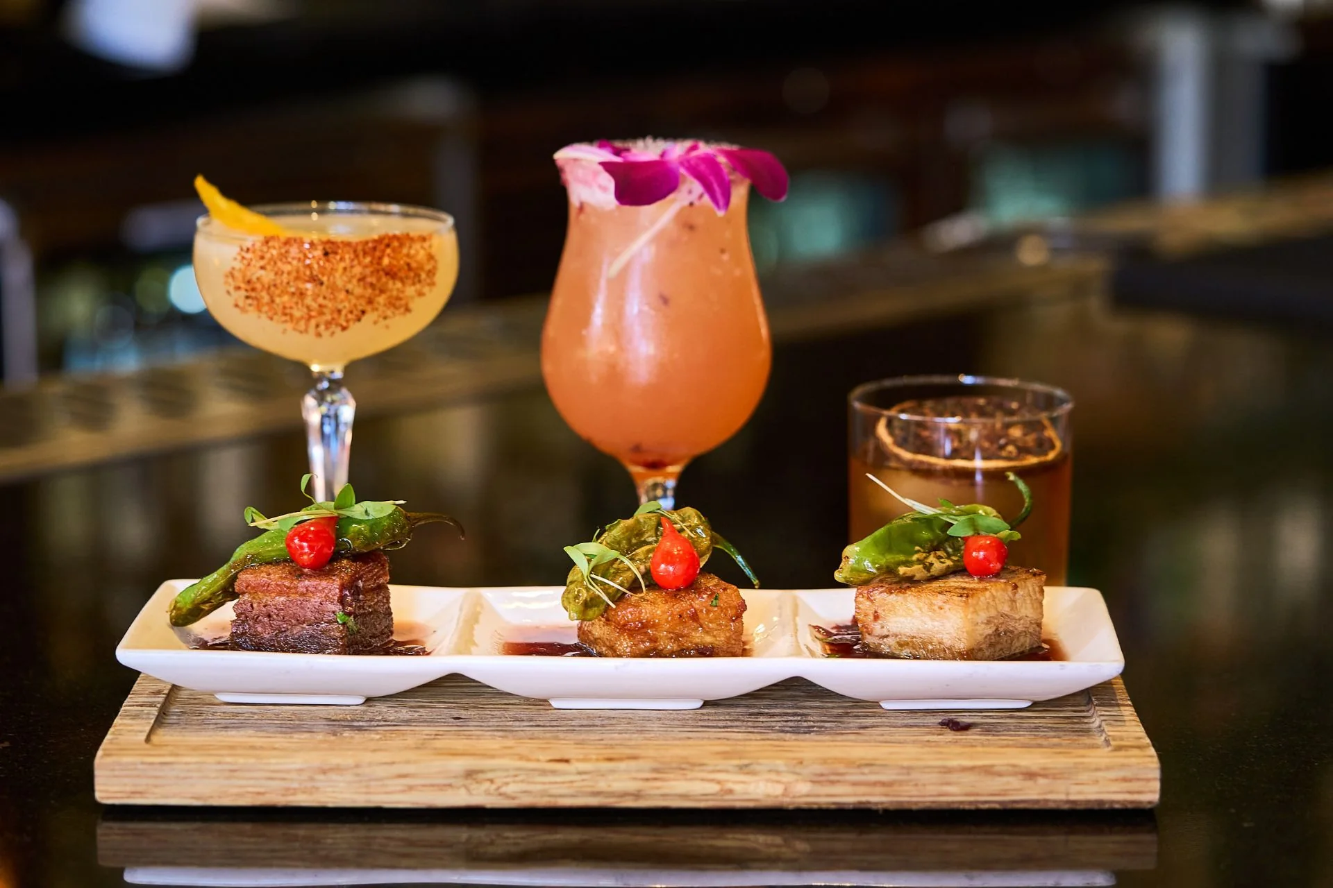 Cocktails and small plates arranged on the bar